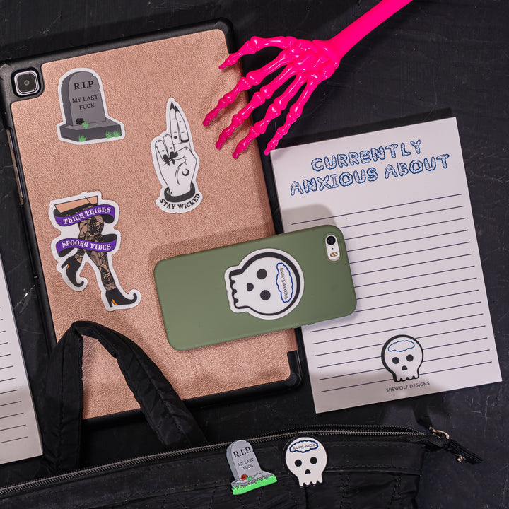 Halloween themed photo shoot with various enamel pins, stickers and a notepad