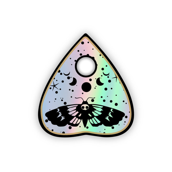 Holographic sticker in the shape of a planchette used for ouija boards. Includes a death moth, moon phase design and stars.